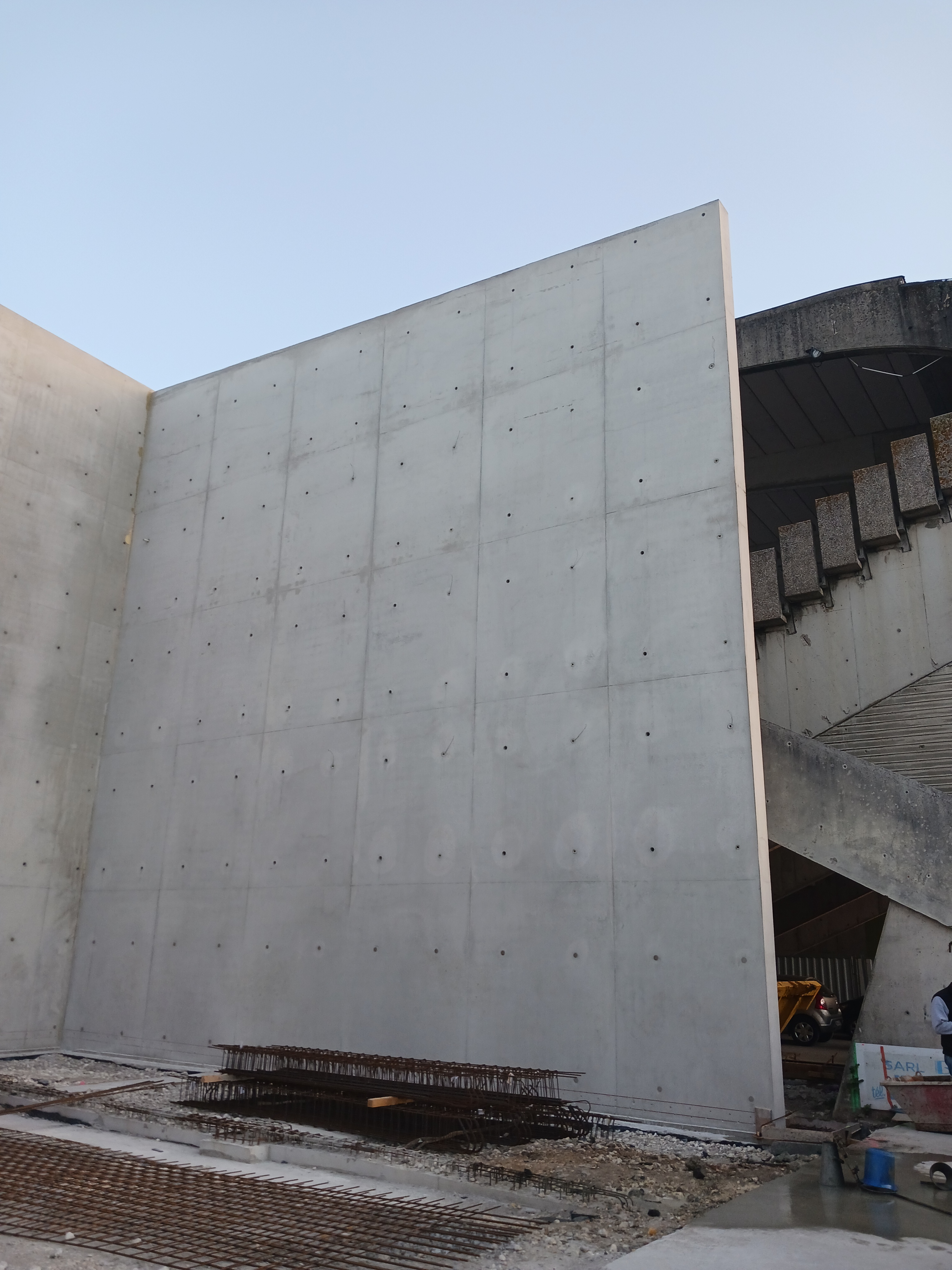 Mur en béton sur un site de construction avec un escalier adjacent.