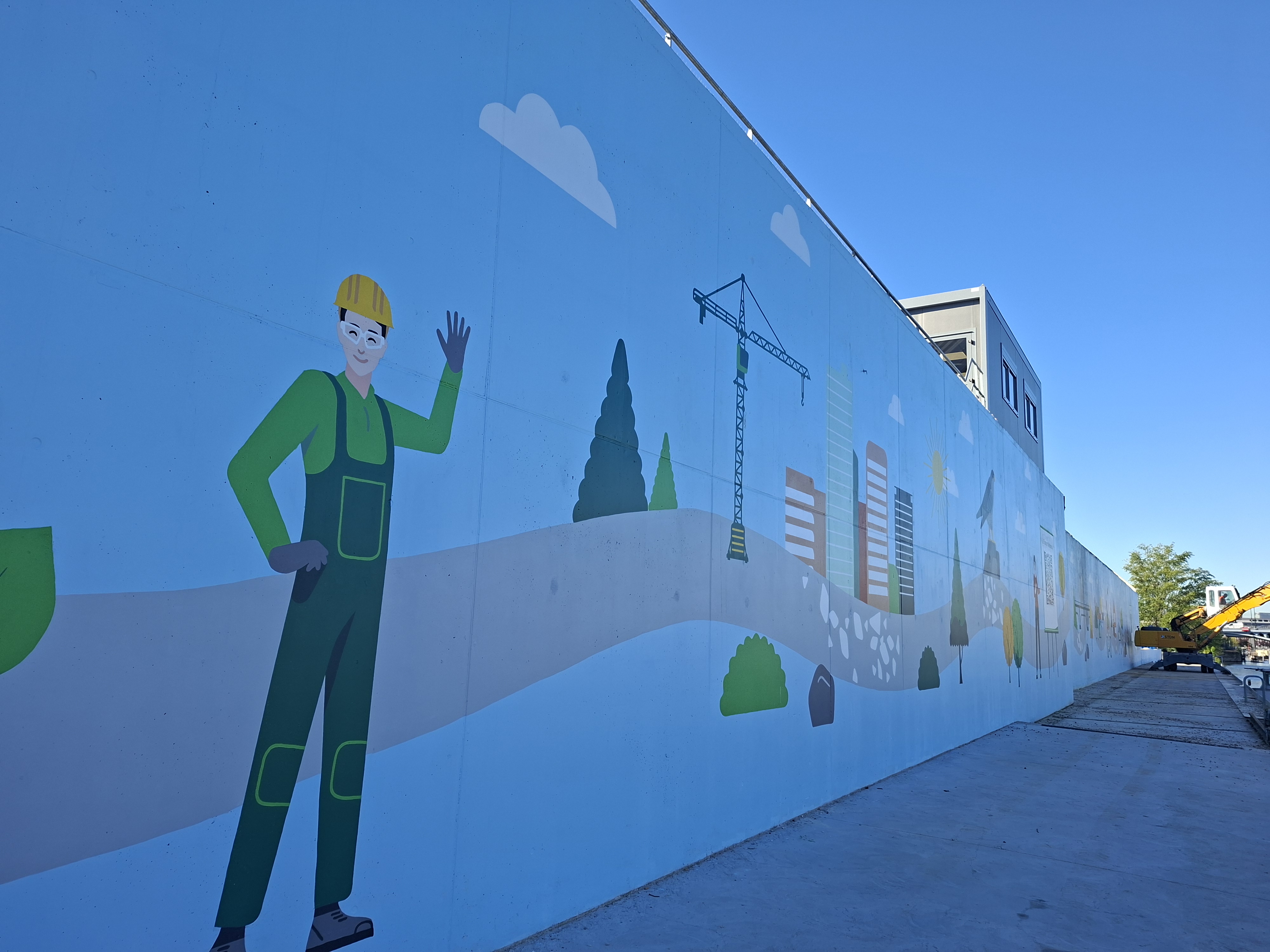 Illustration murale représentant un ouvrier en casque jaune devant des bâtiments et une grue, sur un site de construction.