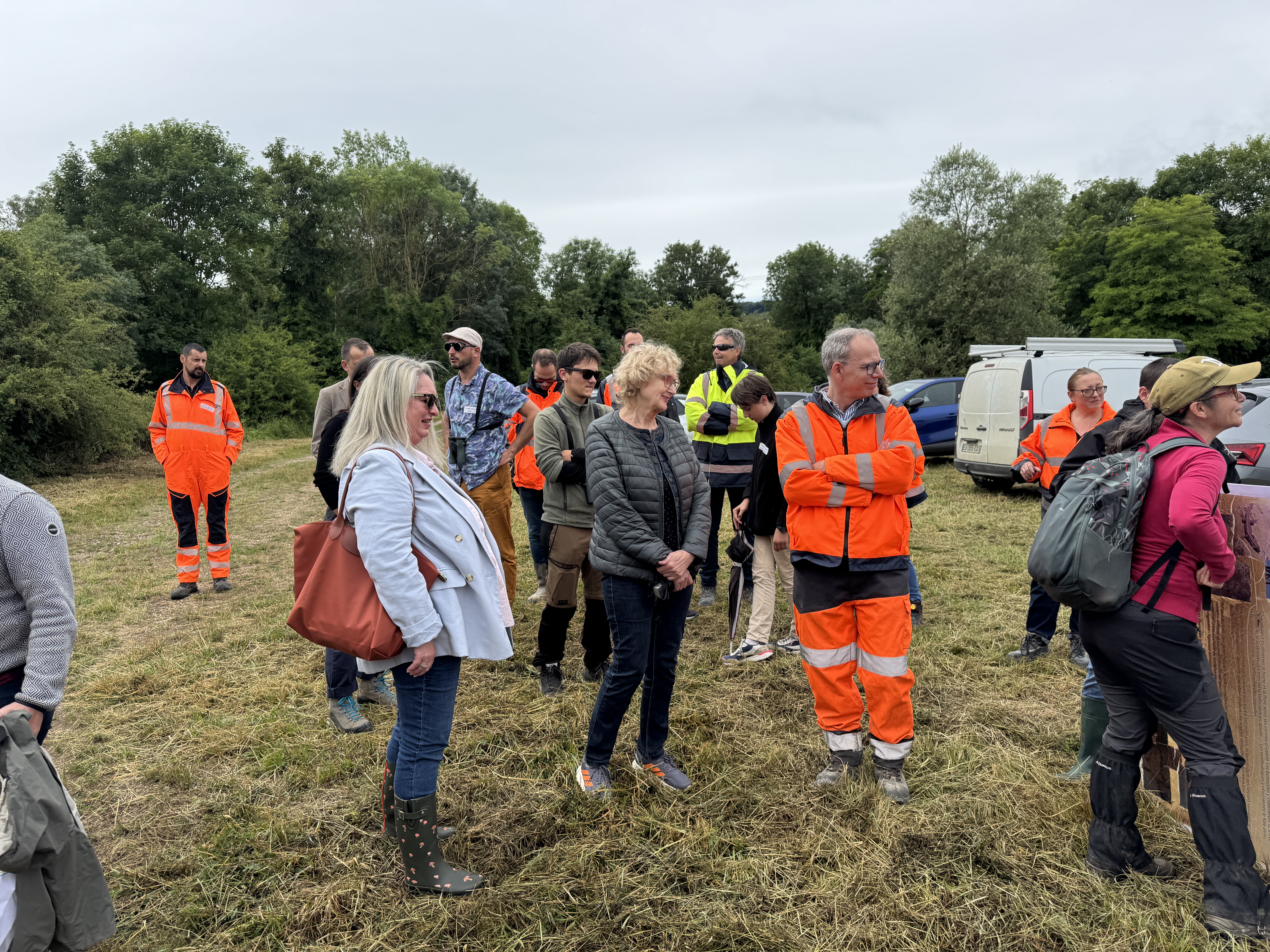 Groupe de personnes sur un site extérieur, dont certaines portent des vêtements haute visibilité.