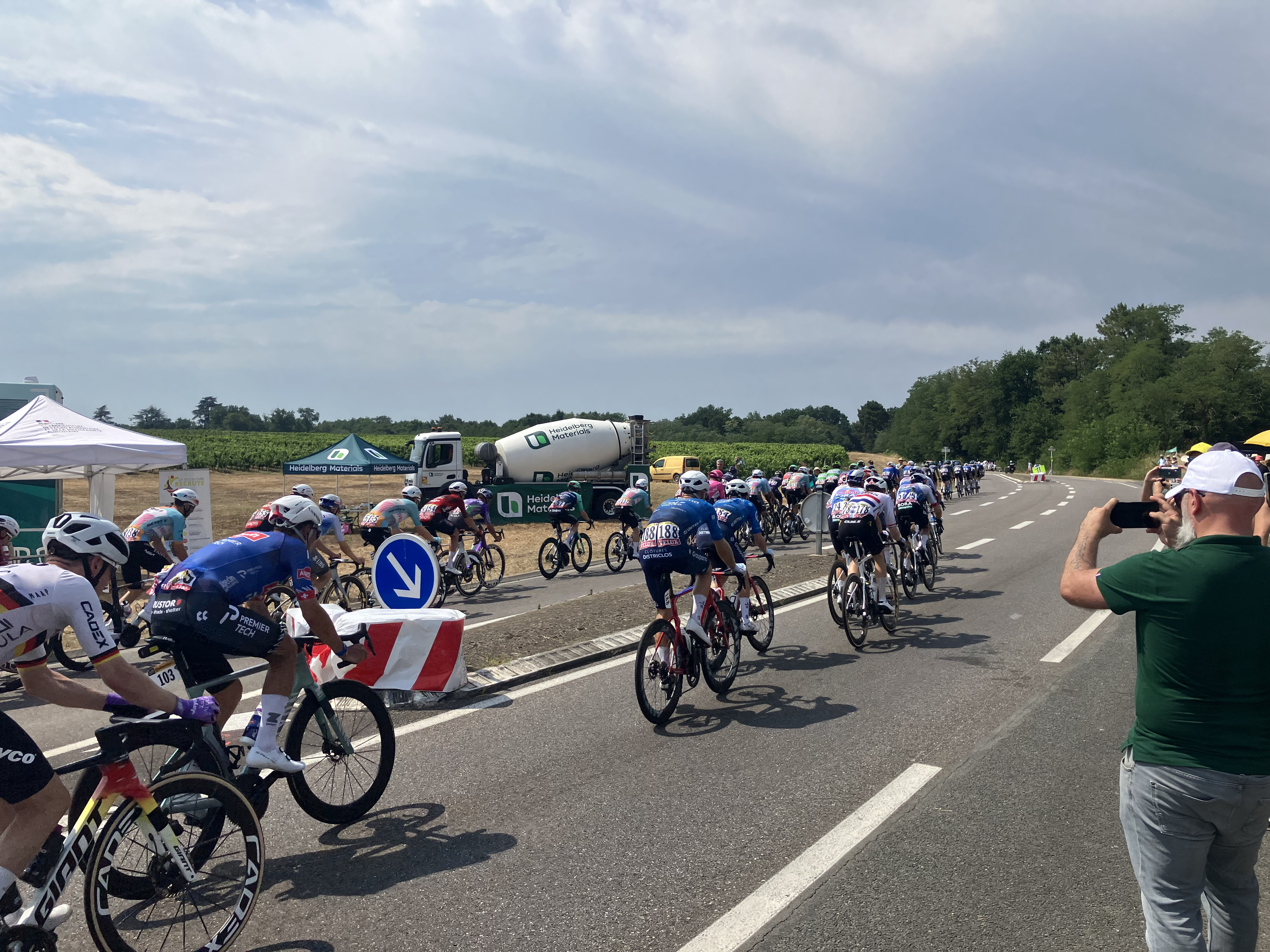 Le peloton du Tour de France 2026 traverse Illats devant la fan zone soutenue par Heidelberg Materials, installée le long de la D11.