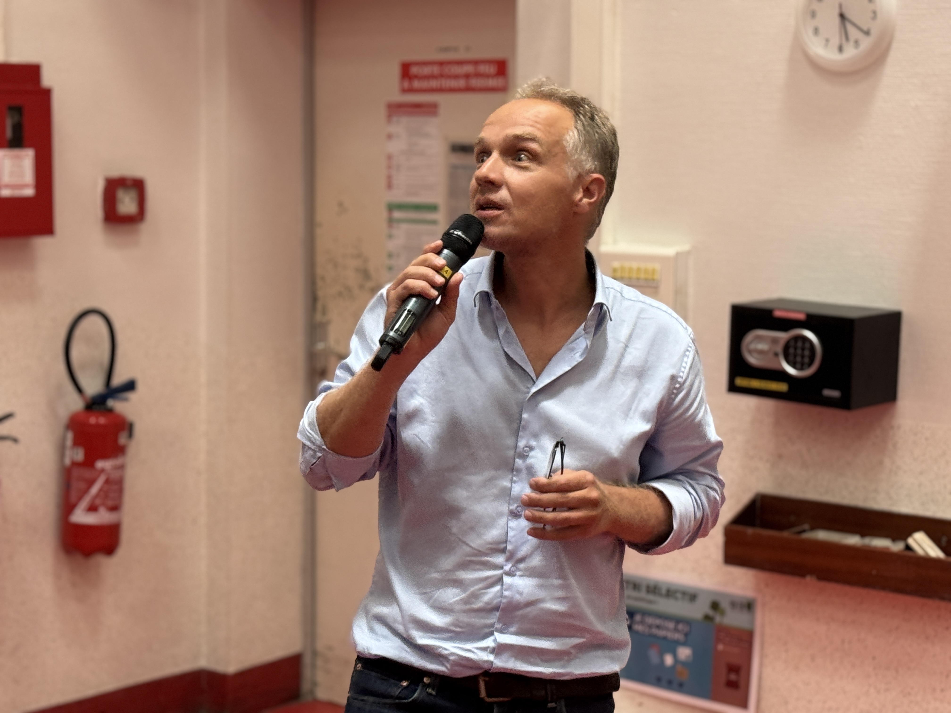 Une personne parlant dans un micro dans un environnement intérieur.