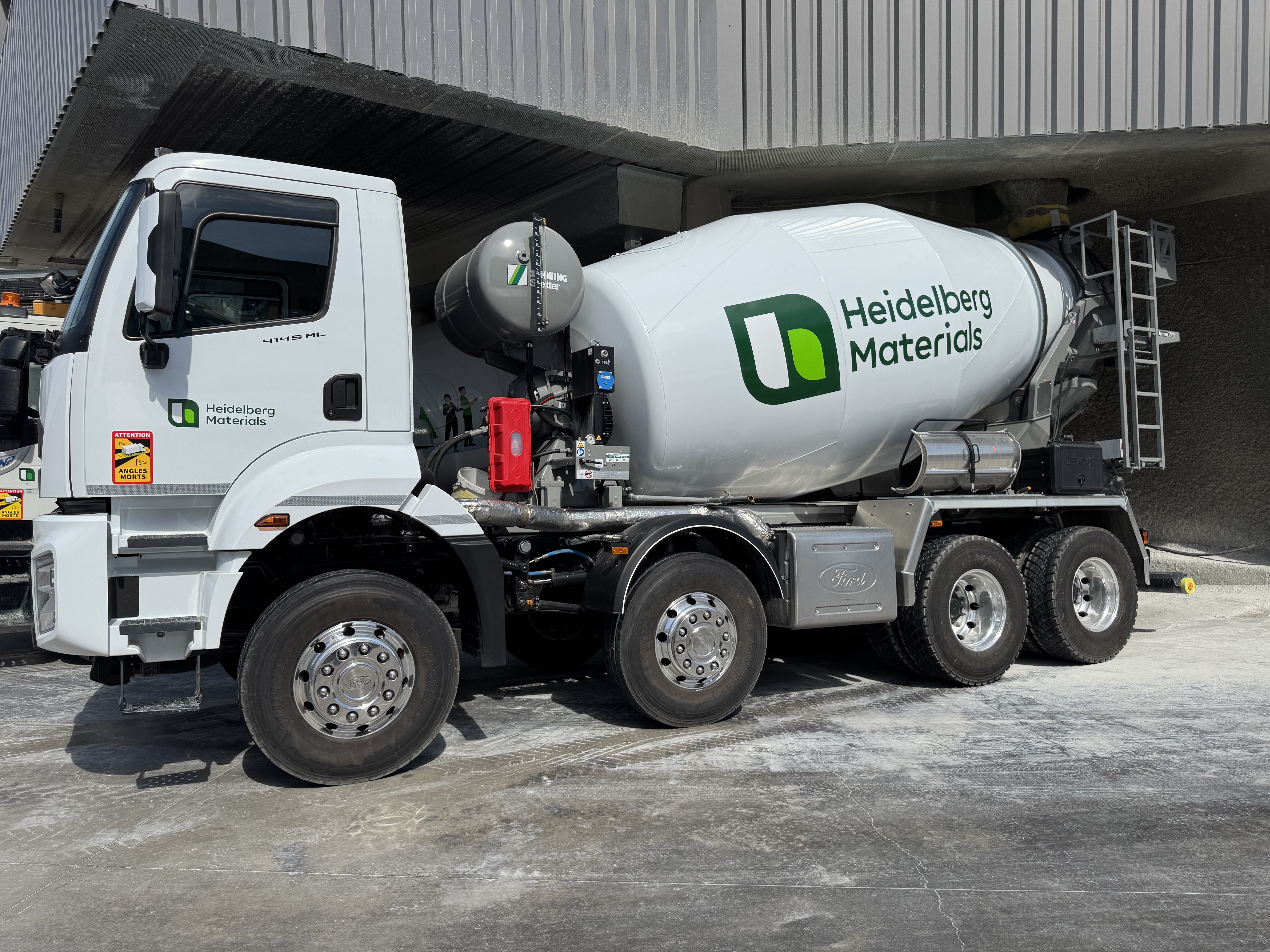 A Heidelberg Materials cement truck is parked on an industrial site.