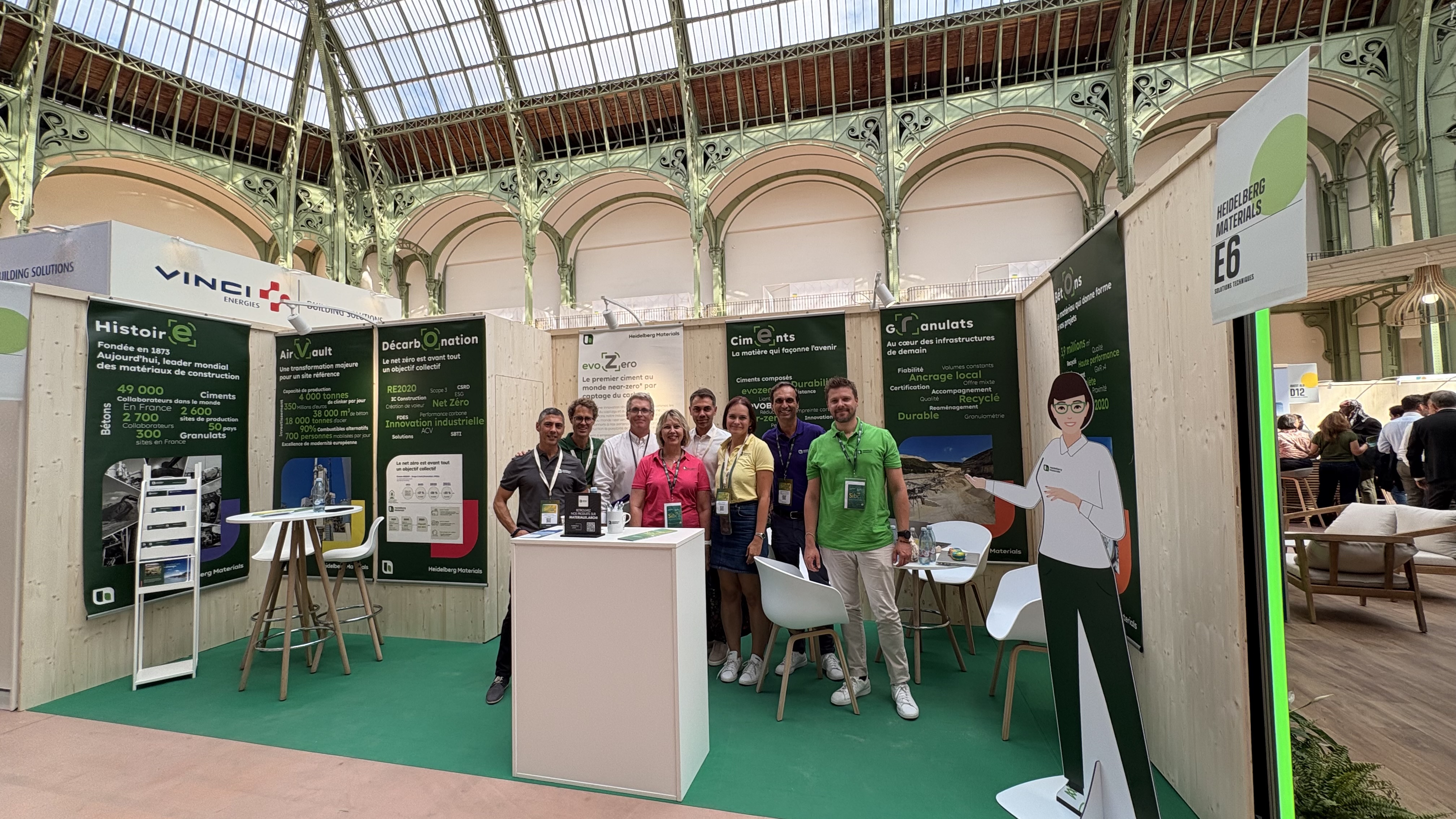 Un stand d'exposition avec plusieurs personnes devant des panneaux présentant des informations sur les matériaux de construction.